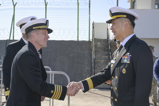 21일 부산작전기지에 입항한 미국 해군 제1항모강습단 항공모함 칼빈슨함(CVN) 앞에서 해군작전사 해양작전본부장 김지훈 준장이 항모 입항을 환영하며 매튜 토마스 칼빈슨함 함장과 악수하고 있다. 연합뉴스